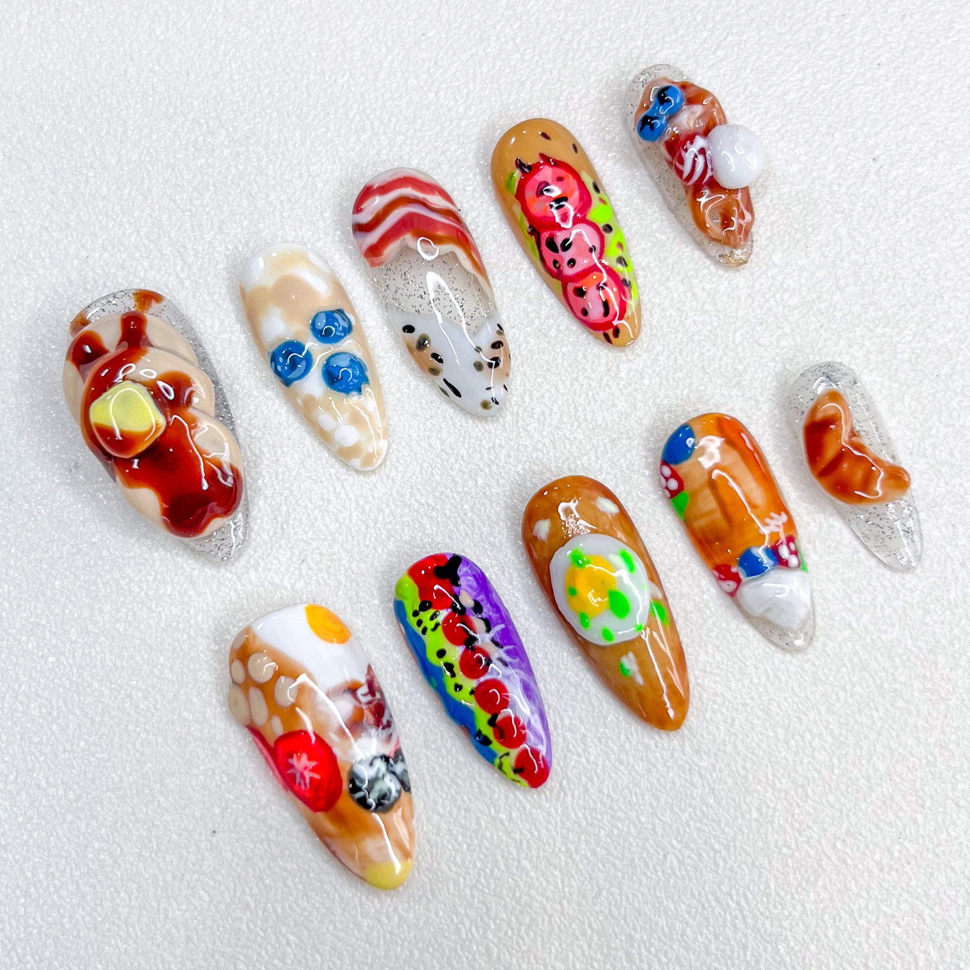 Gourmet Dreams press-on nails with breakfast-inspired designs, including 3D food art like bacon and eggs.