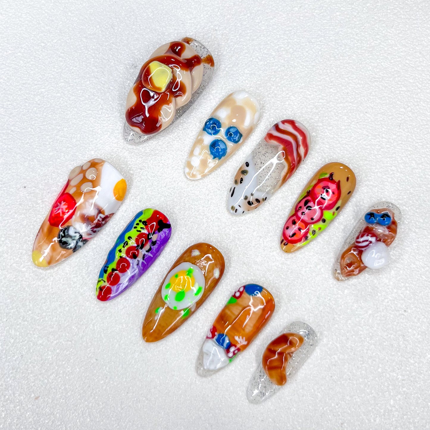 Gourmet Dreams press-on nails with breakfast-inspired designs, including 3D food art like bacon and eggs.