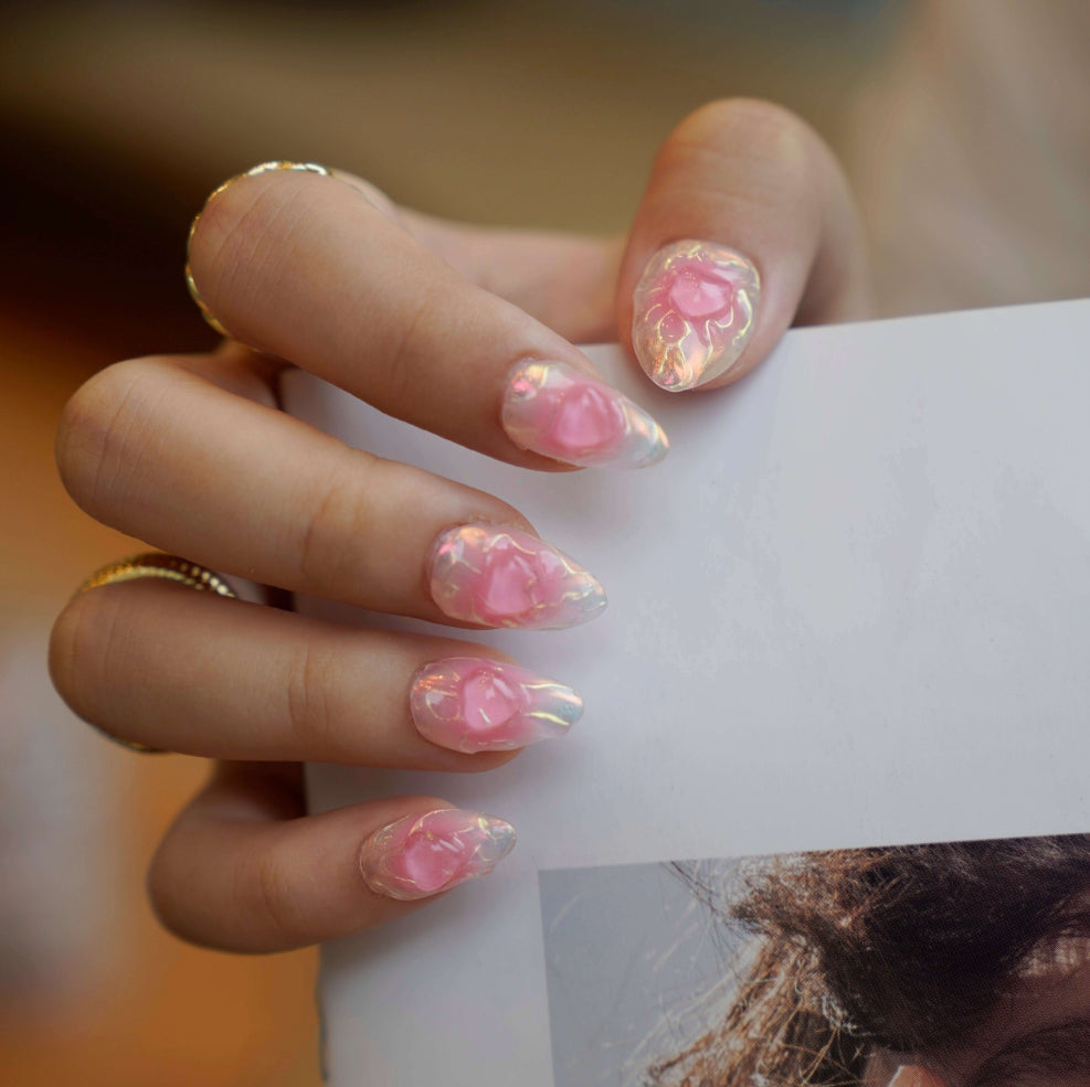 A set of press - on nails with a vibrant pink color and an iridescent finish, giving them a bold and edgy appearance. The nails are perfect for making a statement at parties or events.