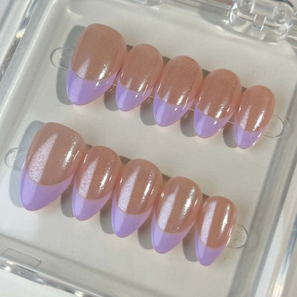 A minimalist press-on nail set with a nude base and delicate lavender French tips, offering a subtle and elegant design suitable for everyday wear or formal occasions.