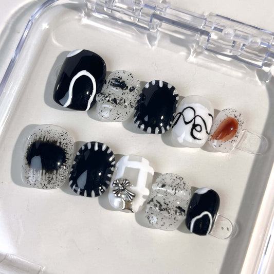 A set of press - on nails with black and white designs, neatly arranged in a transparent case. The nails have a stylish and modern finish, ideal for creating a minimalist yet fashionable appearance, suitable for different occasions.