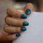 A set of teal glossy press - on nails neatly placed in a transparent box, showcasing a cool, smooth finish, ideal for beach or summer events.