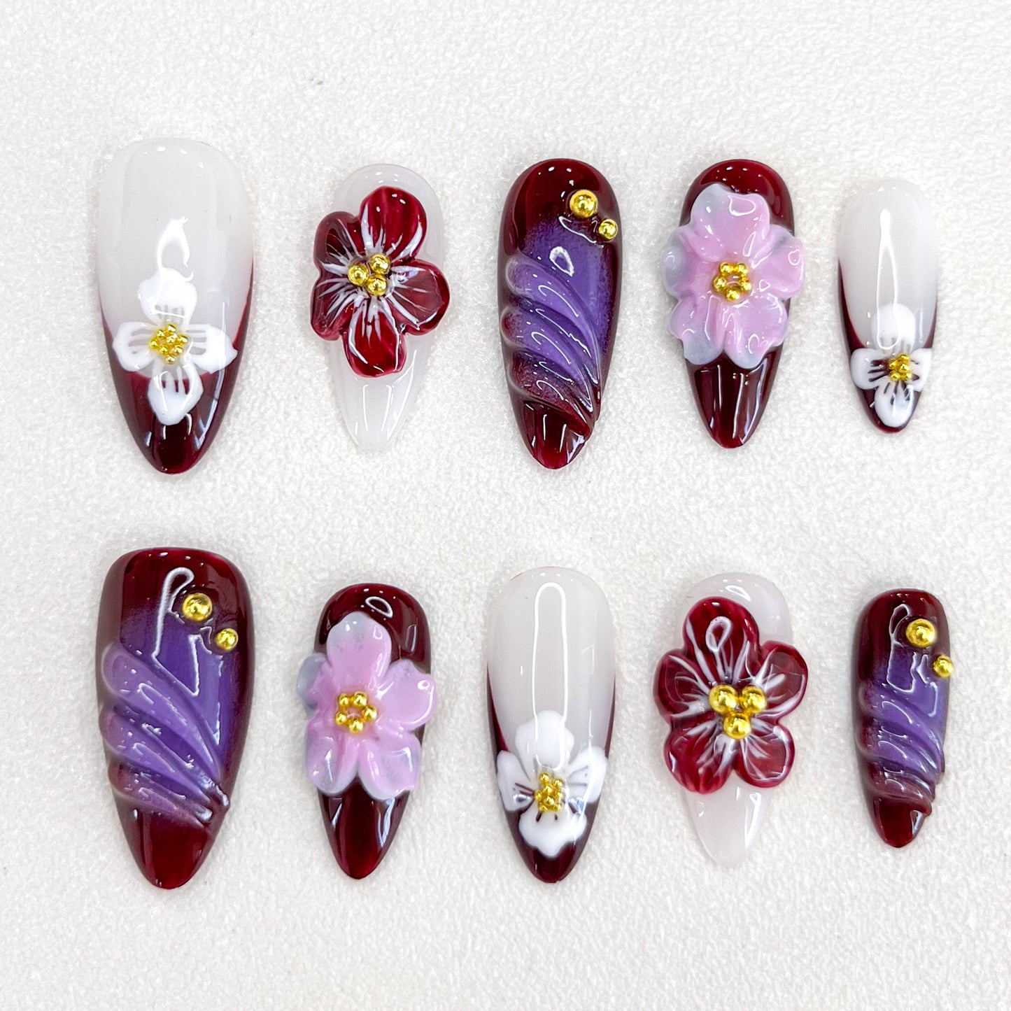 Burgundy Blossoms press-on nails in deep burgundy hues, adorned with delicate flowers, ideal for adding a romantic touch to your look.