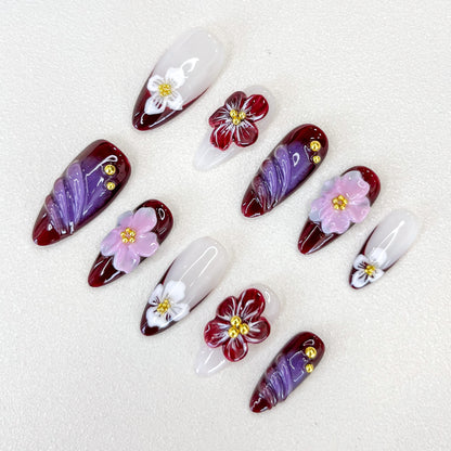 Burgundy Blossoms press-on nails in deep burgundy hues, adorned with delicate flowers, ideal for adding a romantic touch to your look.