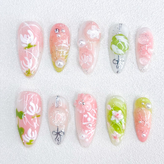 A set of press - on nails with soft pastel colors and delicate floral designs, including leaves and pearl accents. The nails have an ethereal and tranquil appearance, suitable for spring outings or afternoon tea parties.