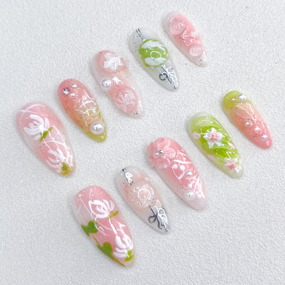 A set of press - on nails with soft pastel colors and delicate floral designs, including leaves and pearl accents. The nails have an ethereal and tranquil appearance, suitable for spring outings or afternoon tea parties.