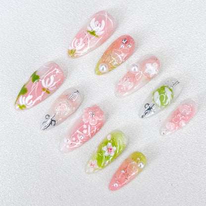 A set of press - on nails with soft pastel colors and delicate floral designs, including leaves and pearl accents. The nails have an ethereal and tranquil appearance, suitable for spring outings or afternoon tea parties.