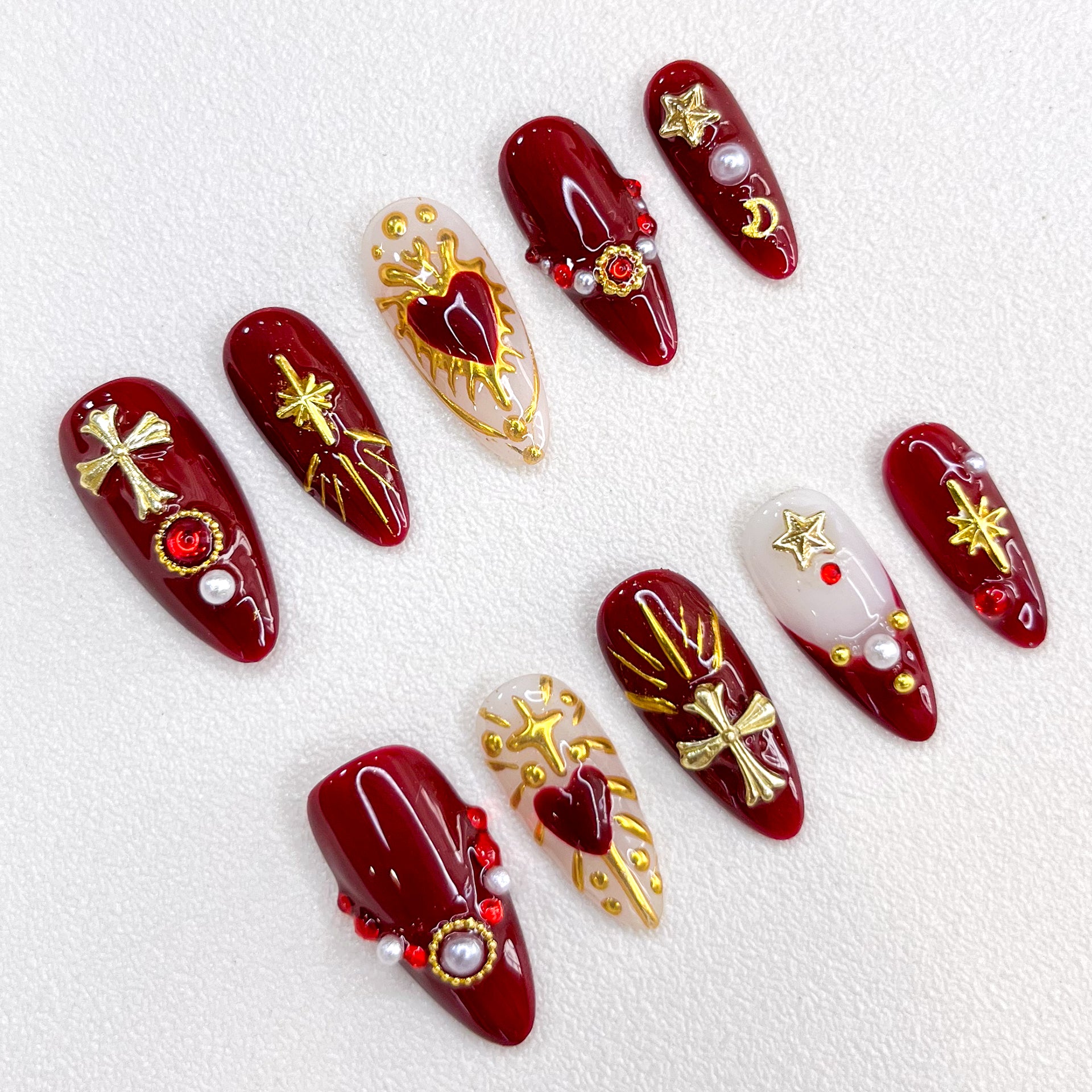 Divine Passion press-on nails with bold red and gold designs featuring crosses and celestial motifs, creating a dramatic and powerful style.