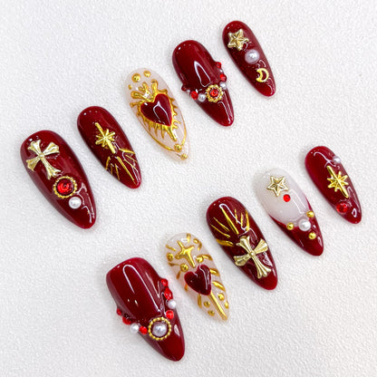 Divine Passion press-on nails with bold red and gold designs featuring crosses and celestial motifs, creating a dramatic and powerful style.