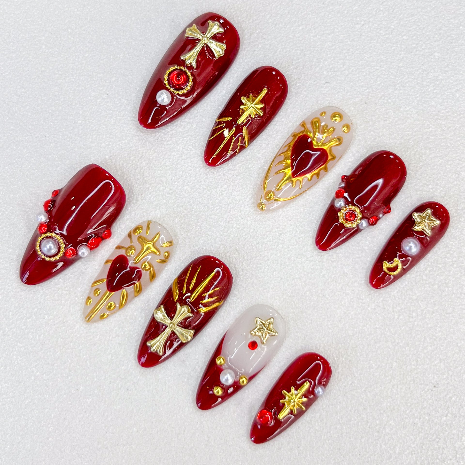 Divine Passion press-on nails with bold red and gold designs featuring crosses and celestial motifs, creating a dramatic and powerful style.