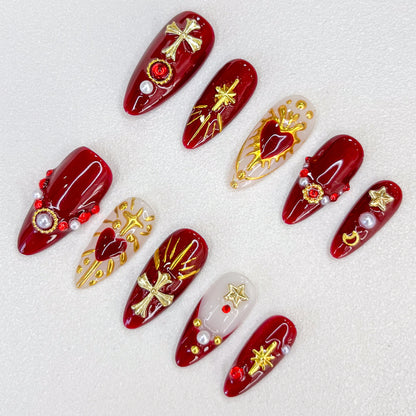 Divine Passion press-on nails with bold red and gold designs featuring crosses and celestial motifs, creating a dramatic and powerful style.