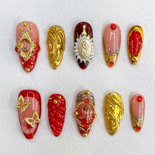 Golden Reverence press-on nails with intricate gold accents and angelic motifs, paired with rich red details for a vintage-inspired, timeless look.