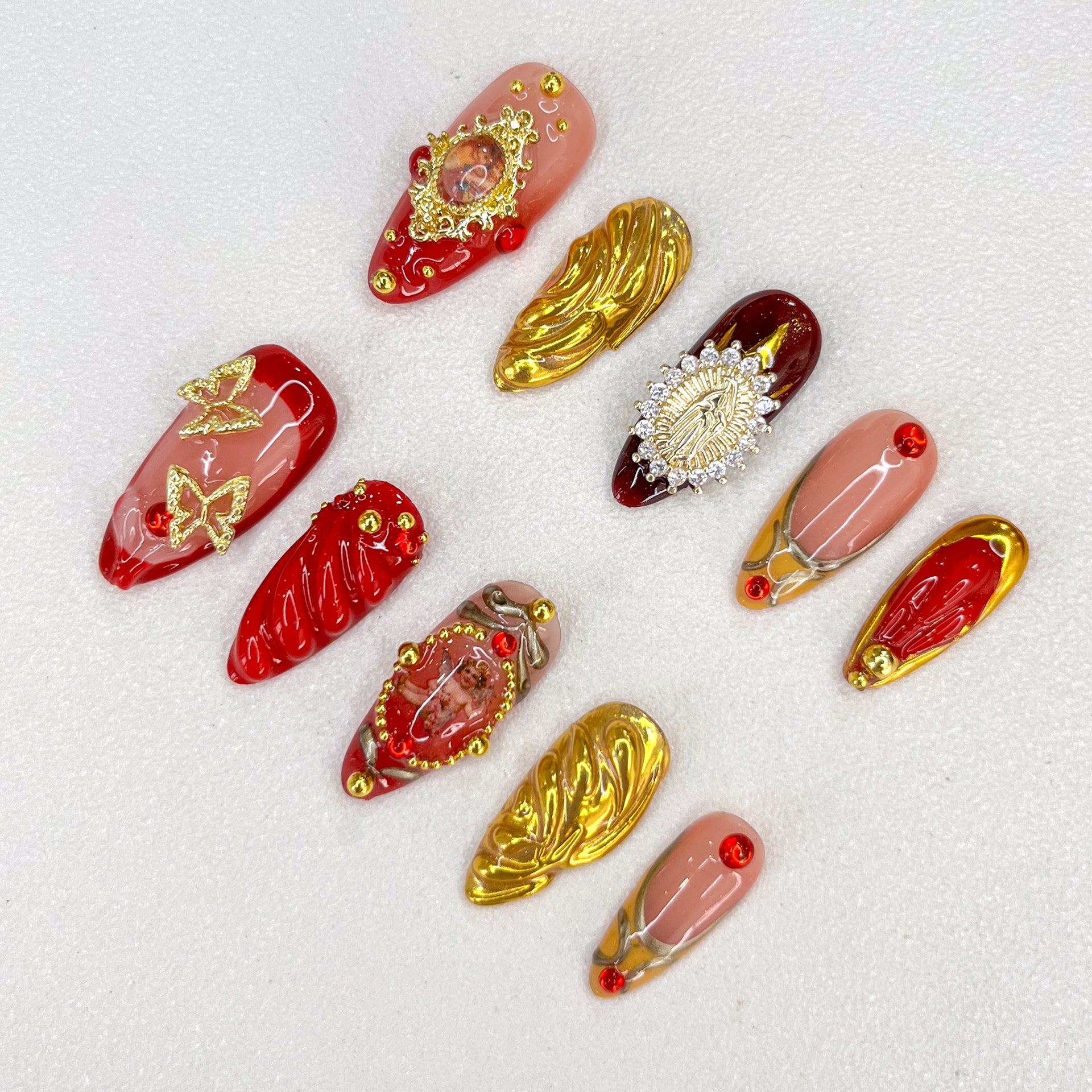 Golden Reverence press-on nails with intricate gold accents and angelic motifs, paired with rich red details for a vintage-inspired, timeless look.