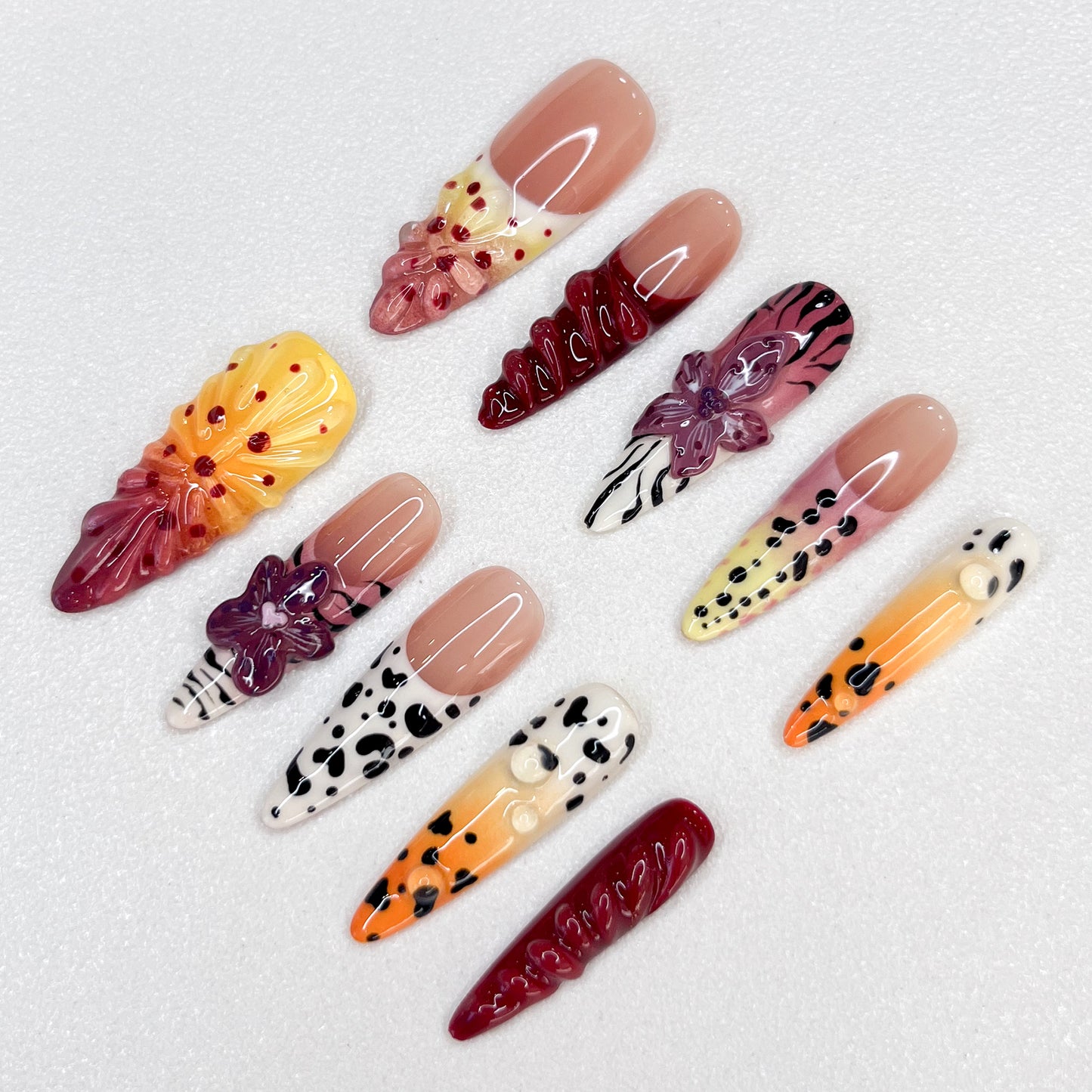 Safari Sunset press-on nails with vibrant sunset hues, animal prints, and floral details, offering an adventurous and bold style.