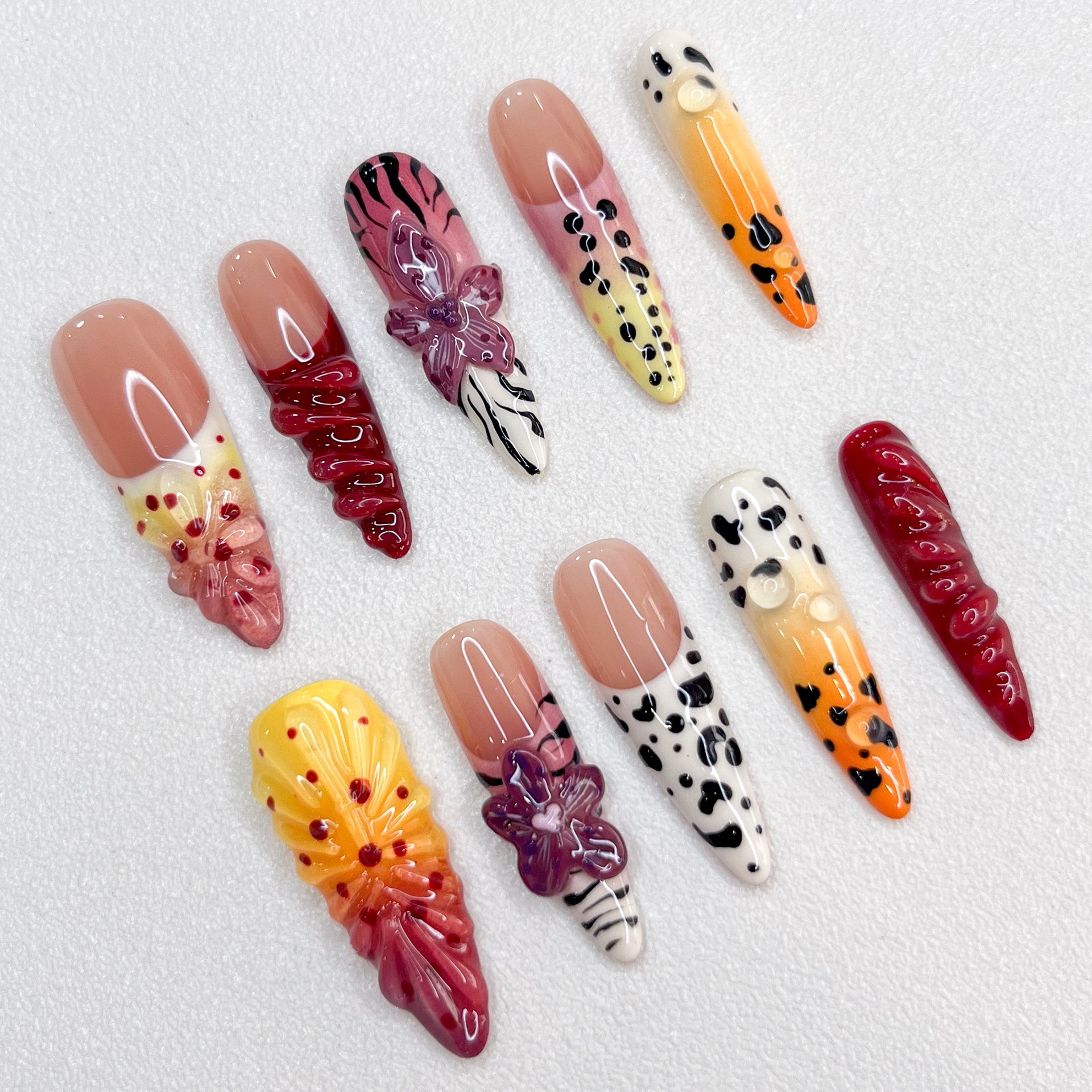 Safari Sunset press-on nails with vibrant sunset hues, animal prints, and floral details, offering an adventurous and bold style.