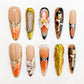 Amber Symphony press-on nails showcasing warm amber shades, ornate metallic designs, and classic accents for a luxurious statement.