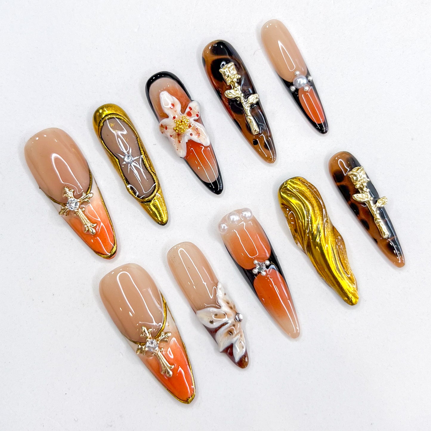 Amber Symphony press-on nails showcasing warm amber shades, ornate metallic designs, and classic accents for a luxurious statement.