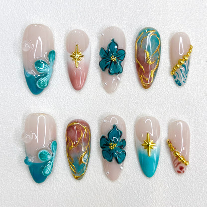 Tidal Serenity press-on nails with coastal-inspired tones, floral patterns, and golden details for a fresh and breezy aesthetic.