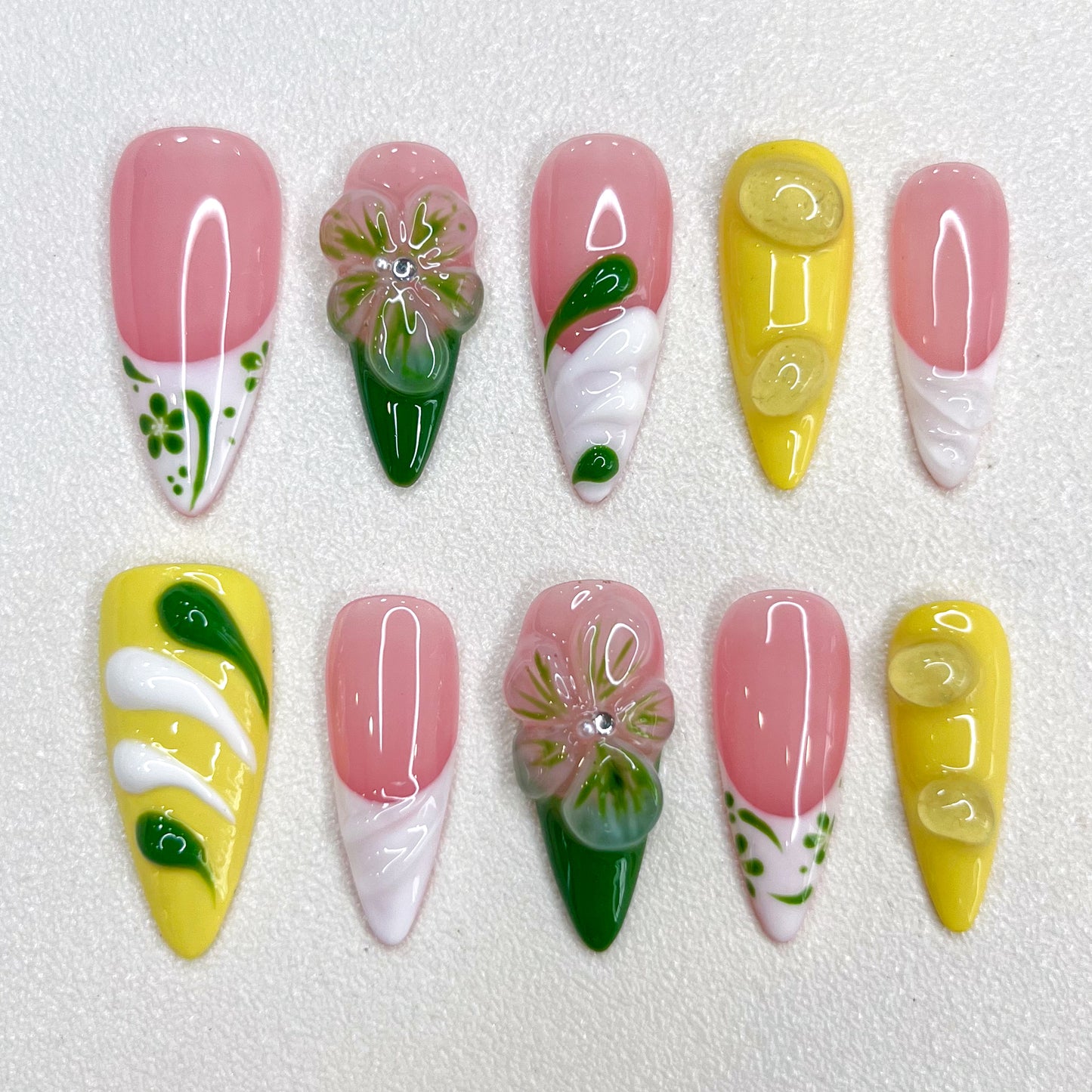 Lemon Fresh press-on nails with pastel yellow tones, swirling green designs, and subtle leaf patterns that evoke a bright and sunny vibe.