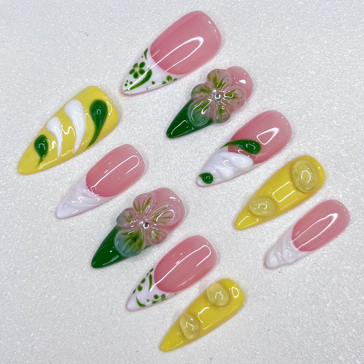 Lemon Fresh press-on nails with pastel yellow tones, swirling green designs, and subtle leaf patterns that evoke a bright and sunny vibe.