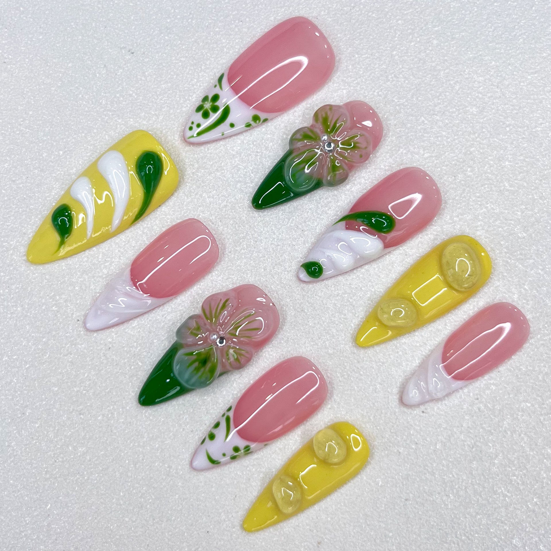 Lemon Fresh press-on nails with pastel yellow tones, swirling green designs, and subtle leaf patterns that evoke a bright and sunny vibe.