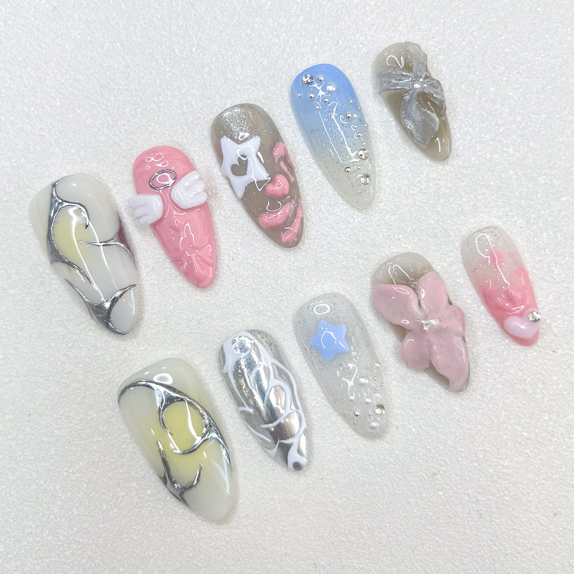 Celestial Dreams press-on nails with soft blue tones, metallic silver accents, and celestial-inspired moon and star decorations for a heavenly finish.