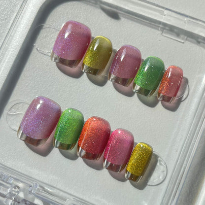 A set of multicolored glittery press - on nails neatly arranged in a transparent case. The nails feature a variety of bright colors with a sparkling finish, ideal for adding a festive and cheerful touch to your look, perfect for parties or celebratory events.