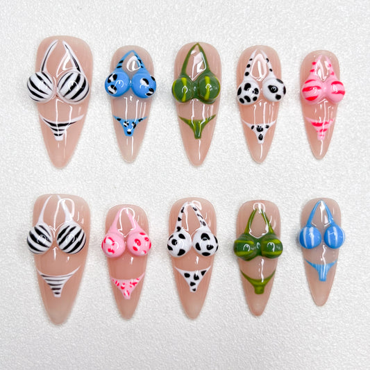 Playful press-on nails featuring 3D bikini designs in zebra stripes, polka dots, florals, and bold colors—ideal for summer and beach-themed manicures.
