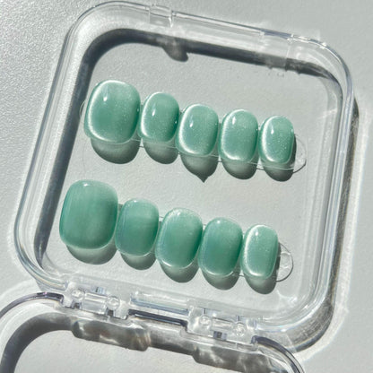 A set of mint - green glossy press - on nails neatly arranged in a transparent case. The nails have a soft, cool finish, ideal for creating a fresh and tranquil look, suitable for spring and summer casual outings or beach vacations.