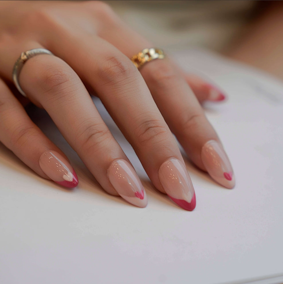 Nude nails with bold red French tips, each adorned with alternating red and white heart accents. This heartfelt design exudes romance and timeless elegance, perfect for adding a touch of love to your style.