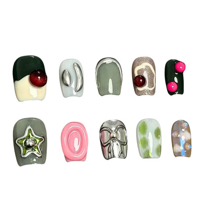 A press-on nail set featuring earthy greens, metallic silver details, and vibrant 3D elements like bows and stars, creating a modern and eclectic aesthetic.