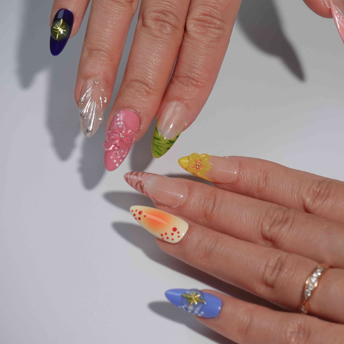 A stunning collection of press-on nails featuring intricate floral motifs, warm gradients, and elegant embellishments like gold stars and shimmer accents. Perfect for showcasing a mix of natural beauty and bold style.