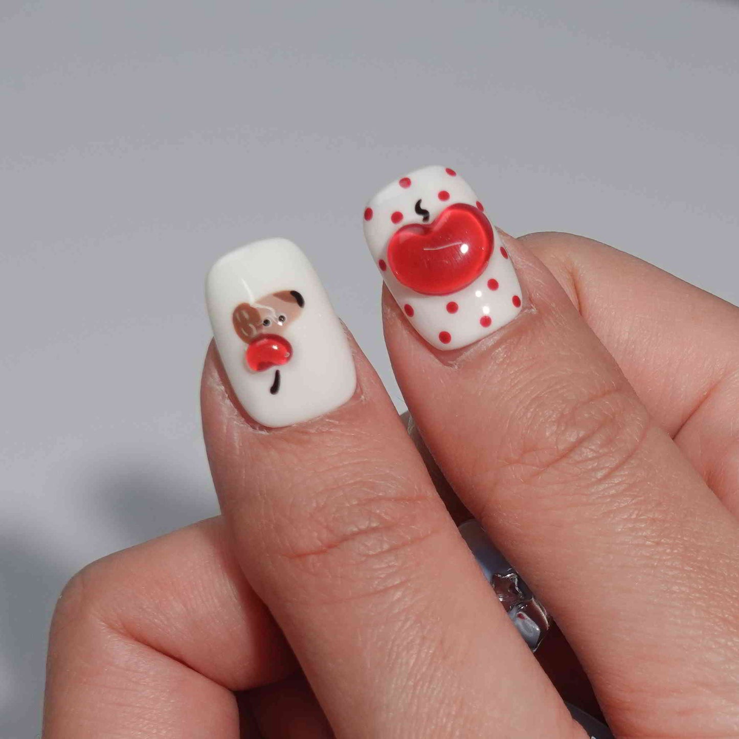 A set of press - on nails with a variety of cute and whimsical designs, including a dog, apple, heart with the word "LOVE", bow, bone, and sparkling elements, neatly arranged in a transparent case. The nails have a playful and charming finish, ideal for casual and fun - filled events.