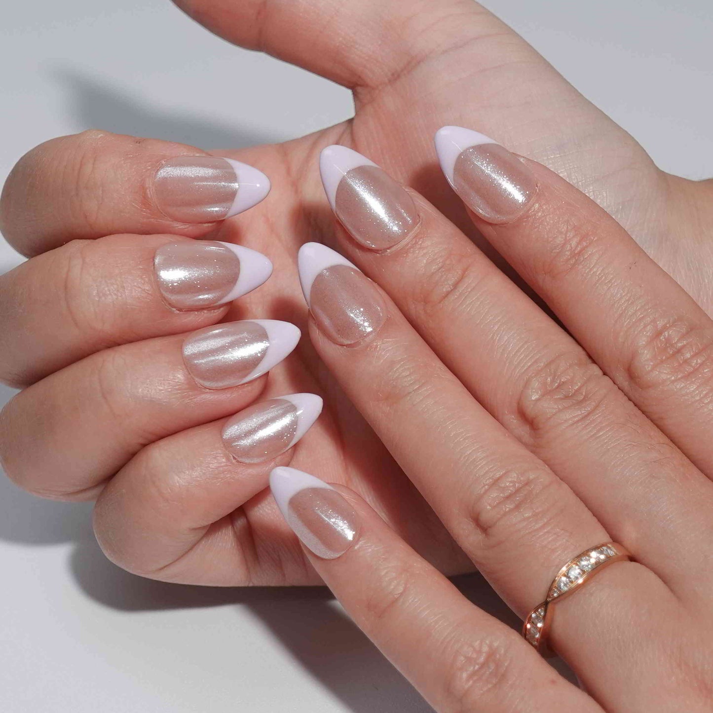 A minimalist press-on nail set with a nude base and delicate lavender French tips, offering a subtle and elegant design suitable for everyday wear or formal occasions.