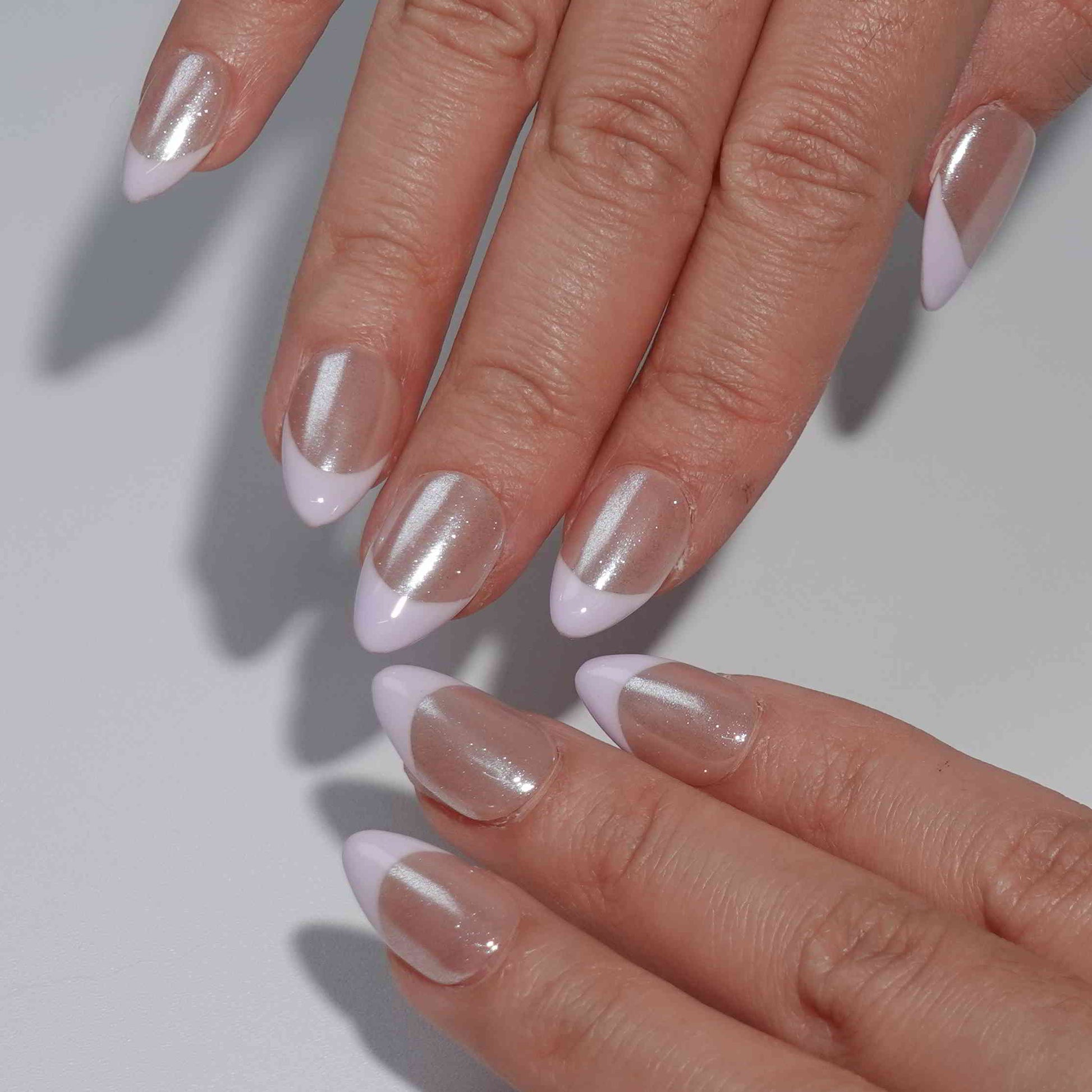 A minimalist press-on nail set with a nude base and delicate lavender French tips, offering a subtle and elegant design suitable for everyday wear or formal occasions.