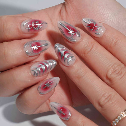 A striking press-on nail set with a red gradient background, adorned with silver metallic details, including abstract floral designs, delicate vines, and celestial star motifs. A perfect choice for a dramatic yet sophisticated look.