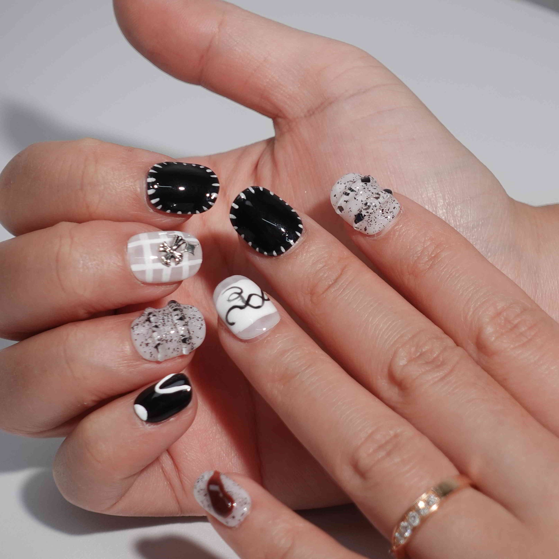 A set of press - on nails with black and white designs, neatly arranged in a transparent case. The nails have a stylish and modern finish, ideal for creating a minimalist yet fashionable appearance, suitable for different occasions.