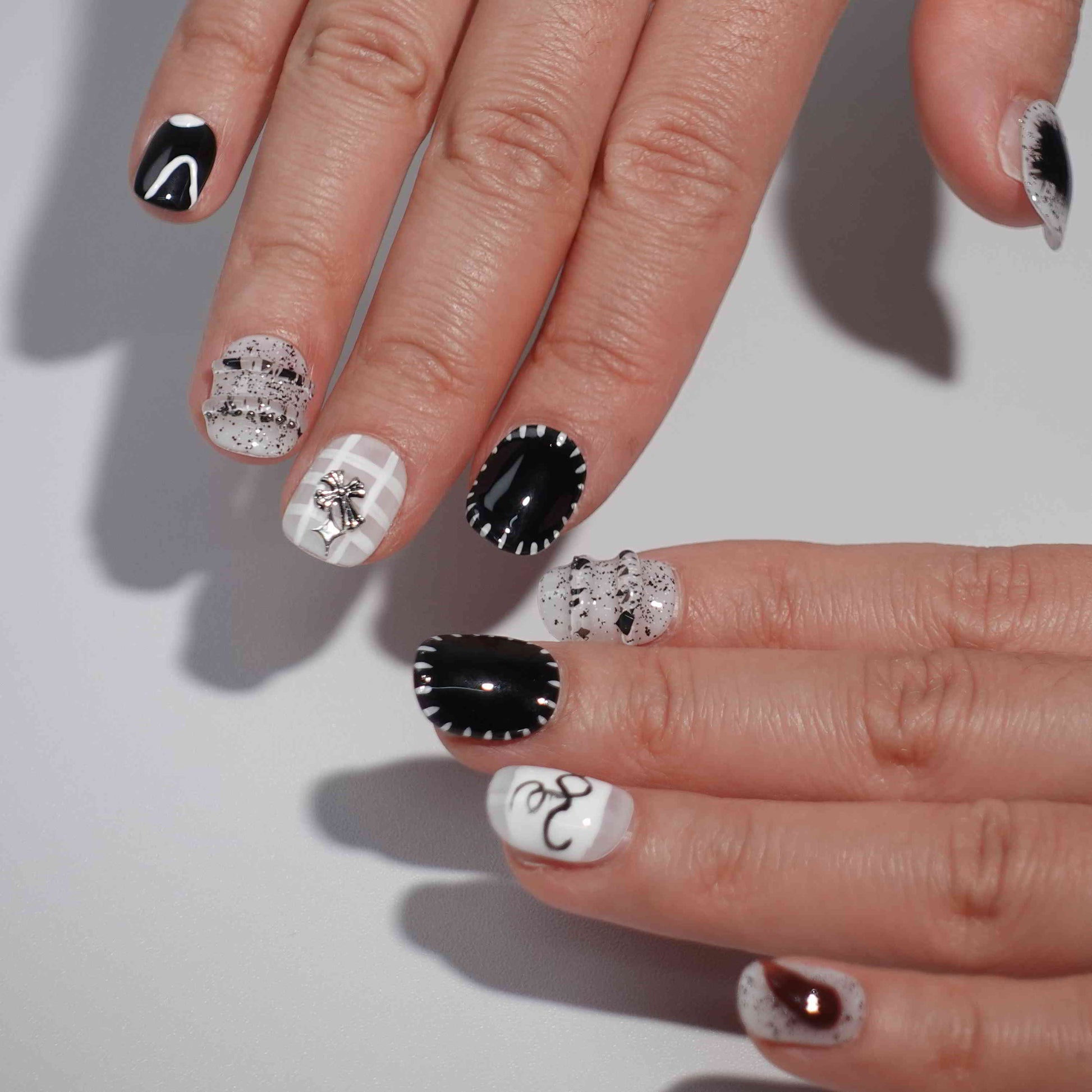 A set of press - on nails with black and white designs, neatly arranged in a transparent case. The nails have a stylish and modern finish, ideal for creating a minimalist yet fashionable appearance, suitable for different occasions.