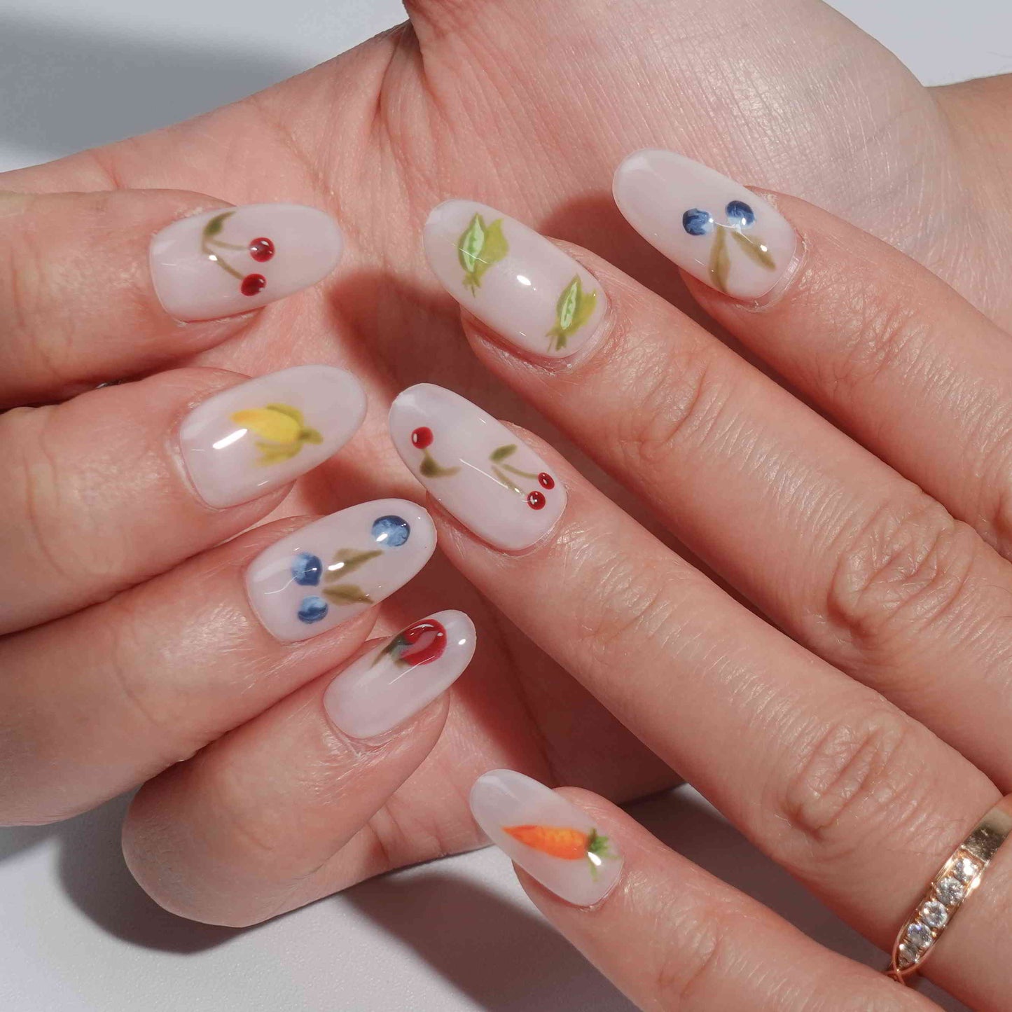 A set of press - on nails with colorful fruit illustrations including cherries, blueberries, carrots, lemons, and peas. The nails have a fresh and lively appearance, ideal for summer outings or fruit - themed parties.