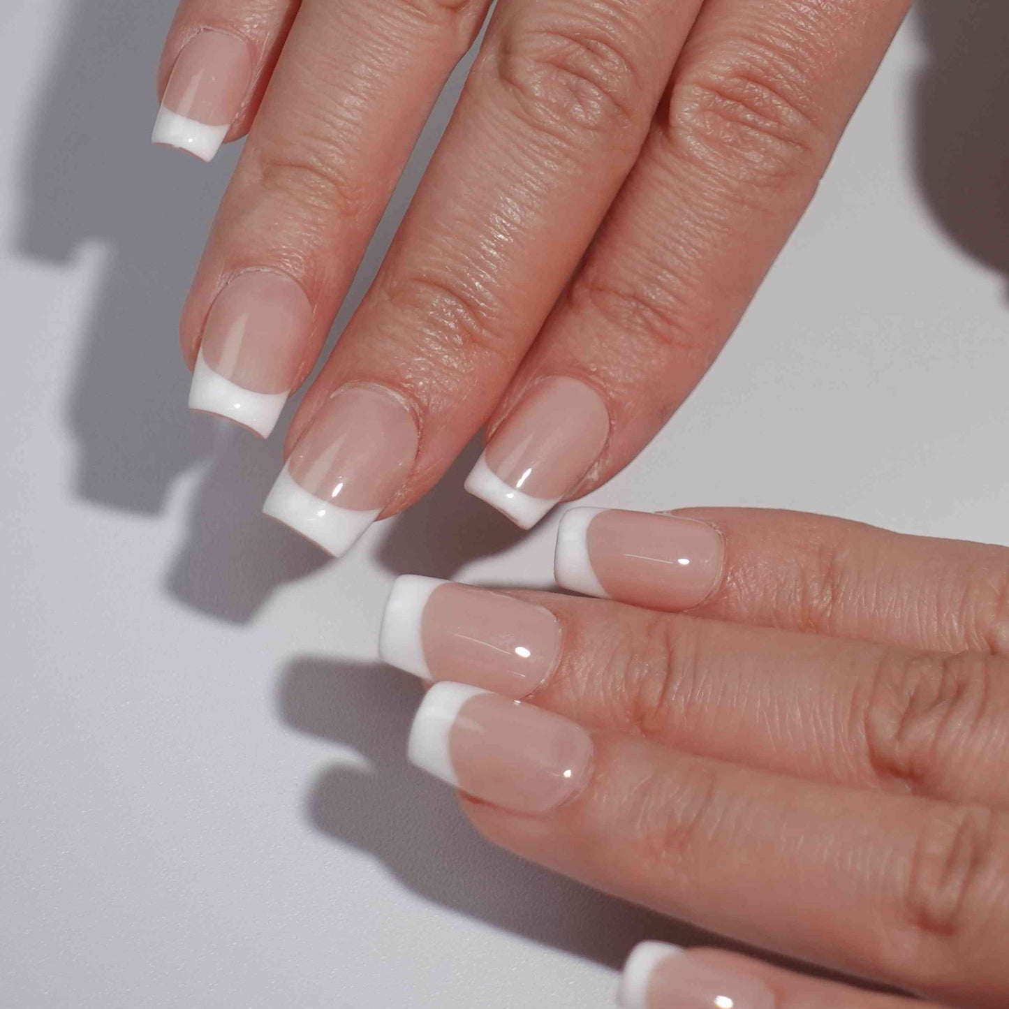 Square-shaped French nails with white tips and a nude base, delivering a clean and polished style perfect for various settings