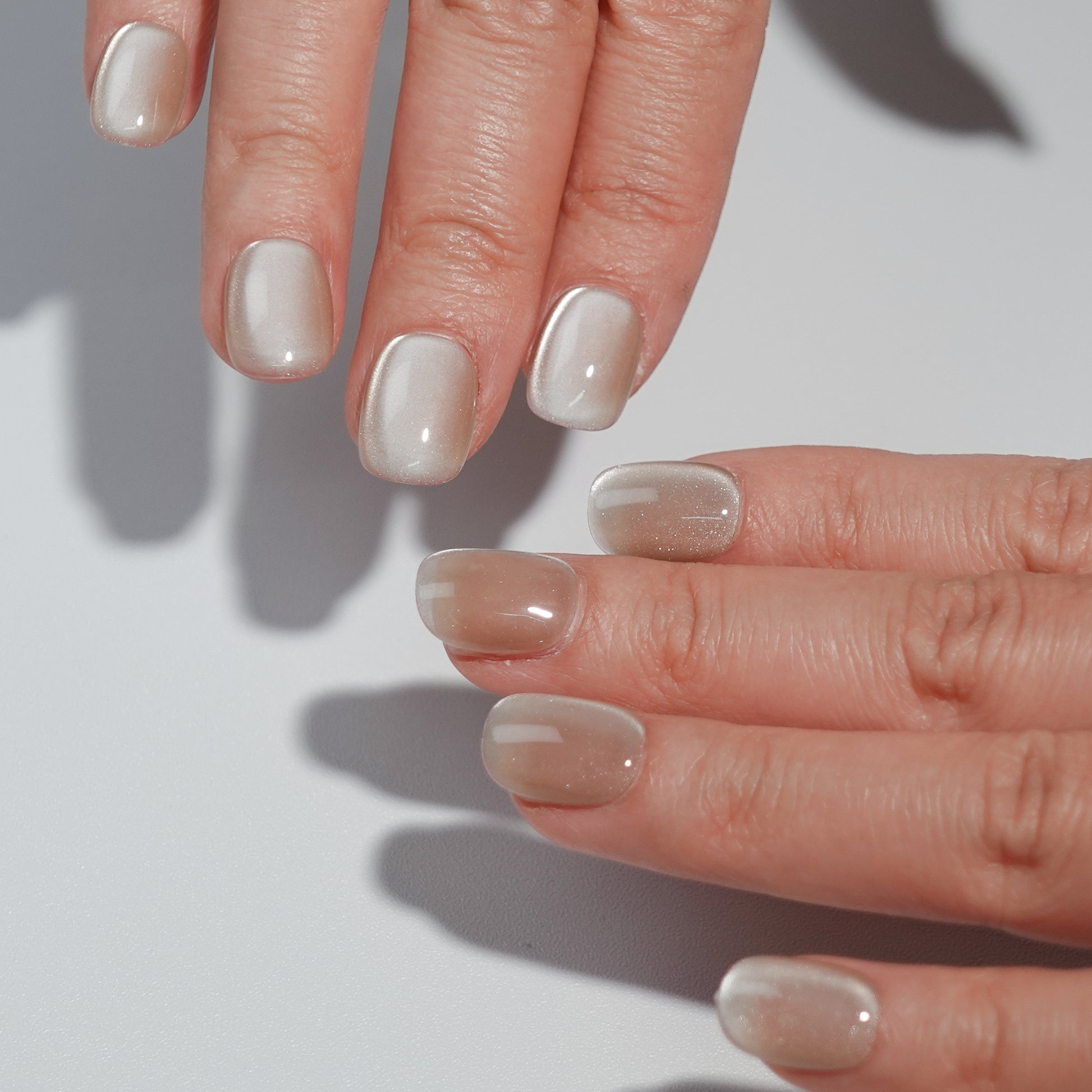 A set of ivory - colored glossy press - on nails neatly arranged in a transparent case, featuring a subtle and smooth finish, ideal for professional or formal occasions.