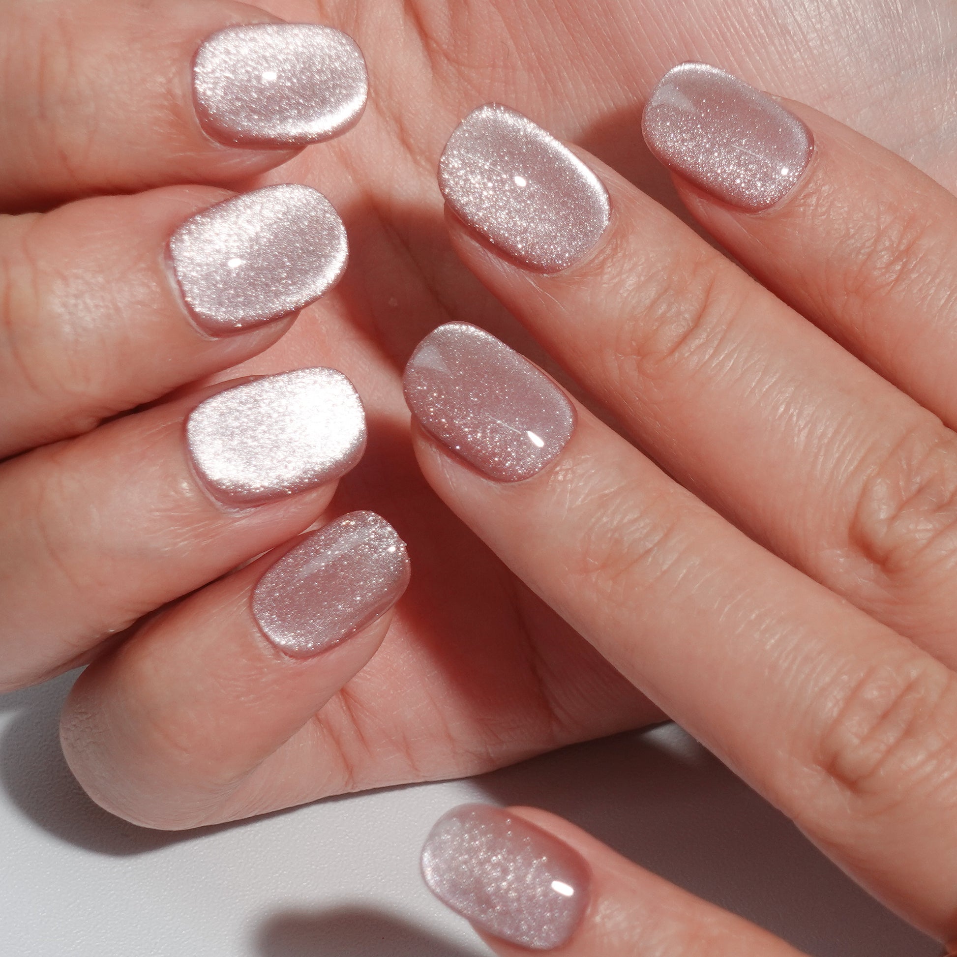 A set of champagne - colored glittery press - on nails neatly arranged in a transparent case. The nails have a sparkling finish, ideal for adding a festive and luxurious touch to your look, perfect for weddings or parties.