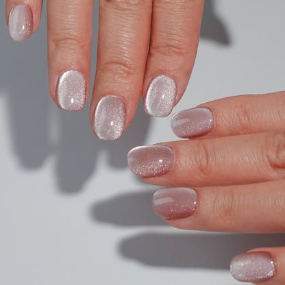 A set of champagne - colored glittery press - on nails neatly arranged in a transparent case. The nails have a sparkling finish, ideal for adding a festive and luxurious touch to your look, perfect for weddings or parties.