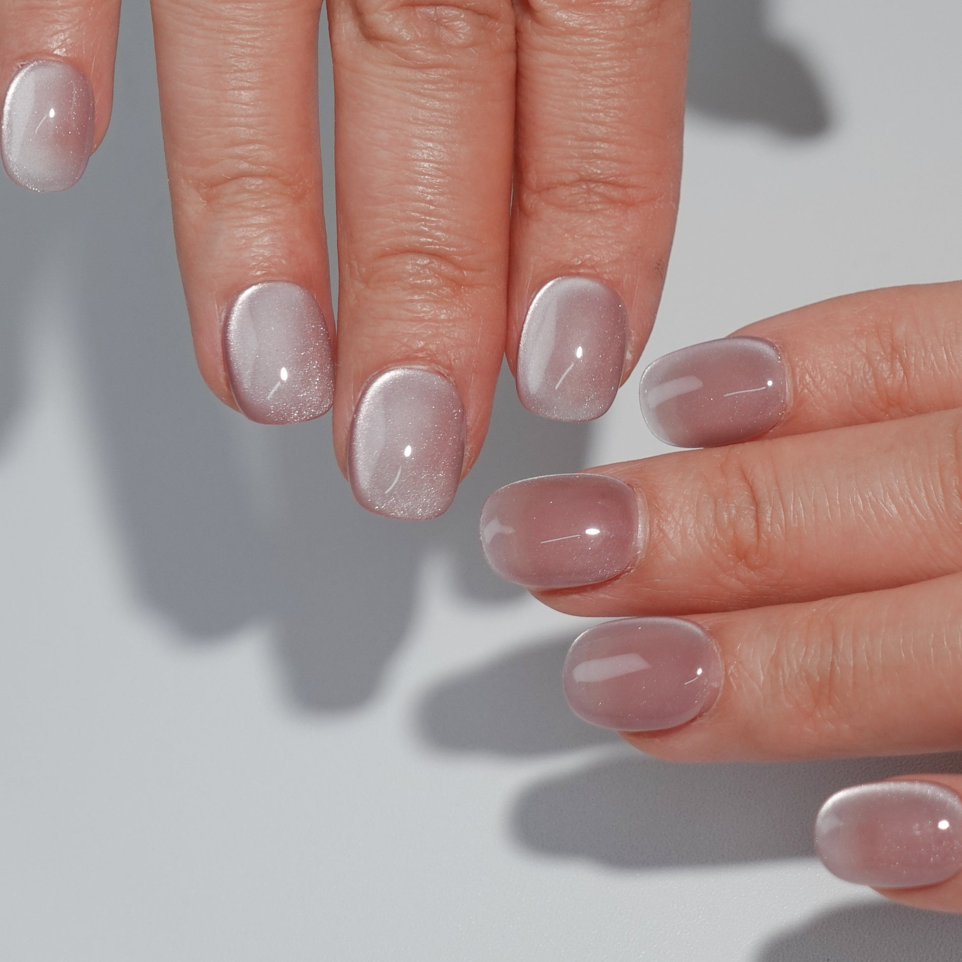 A set of rose - colored press - on nails with a subtle shimmer, neatly arranged in a transparent case. The nails have a soft, glowing finish, ideal for creating a romantic and elegant look, suitable for dates or special occasions.