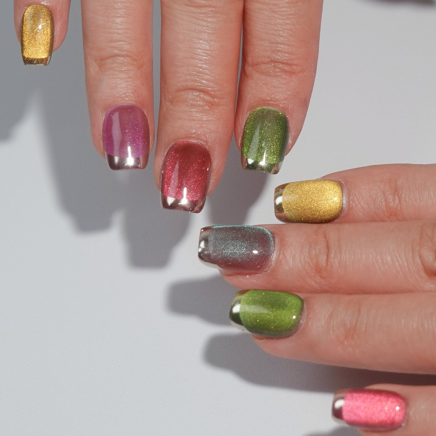 A set of multicolored glittery press - on nails neatly arranged in a transparent case. The nails feature a variety of bright colors with a sparkling finish, ideal for adding a festive and cheerful touch to your look, perfect for parties or celebratory events.