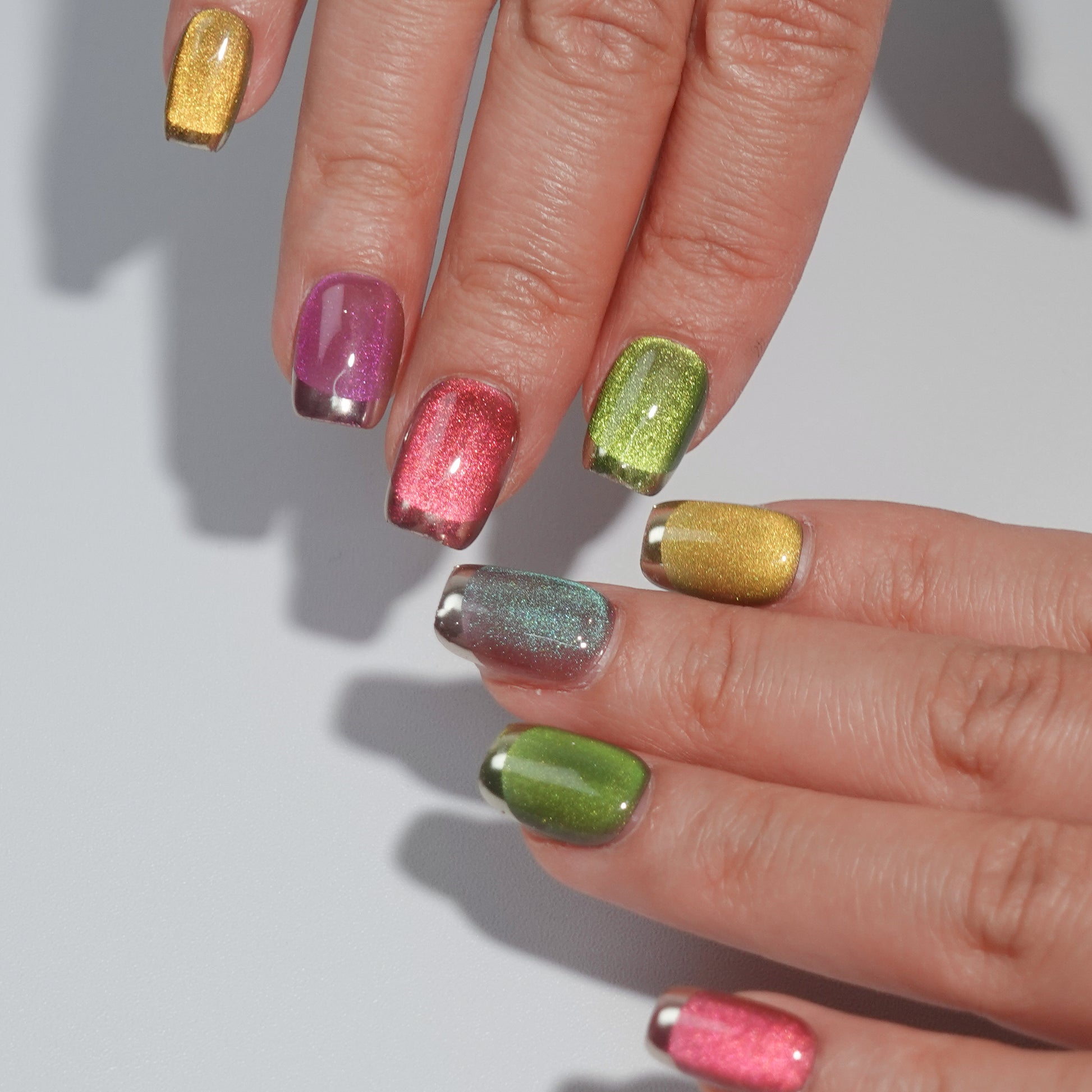 A set of multicolored glittery press - on nails neatly arranged in a transparent case. The nails feature a variety of bright colors with a sparkling finish, ideal for adding a festive and cheerful touch to your look, perfect for parties or celebratory events.