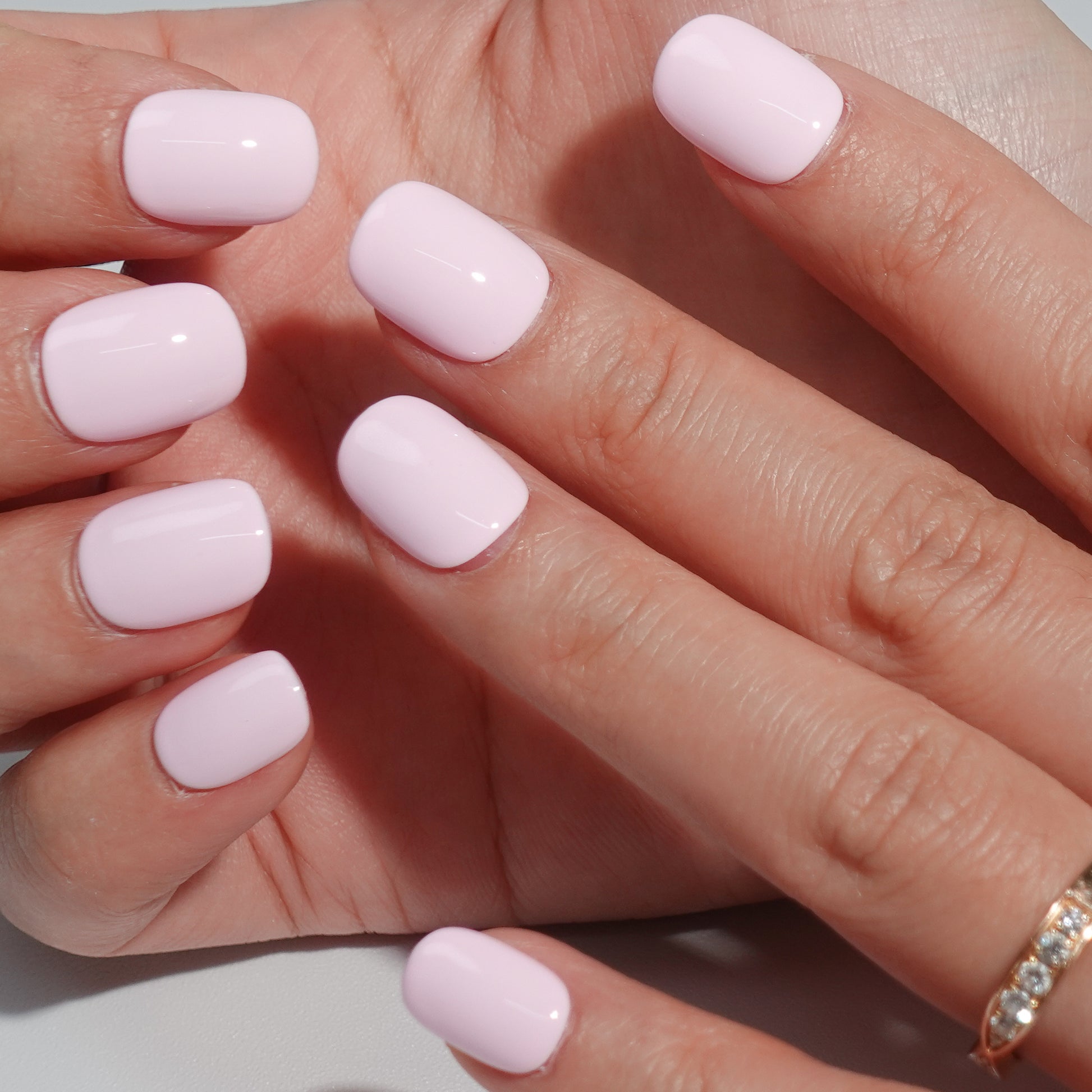 A set of light pink glossy press - on nails neatly arranged in a transparent case, featuring a gentle, smooth finish, ideal for romantic or feminine occasions.