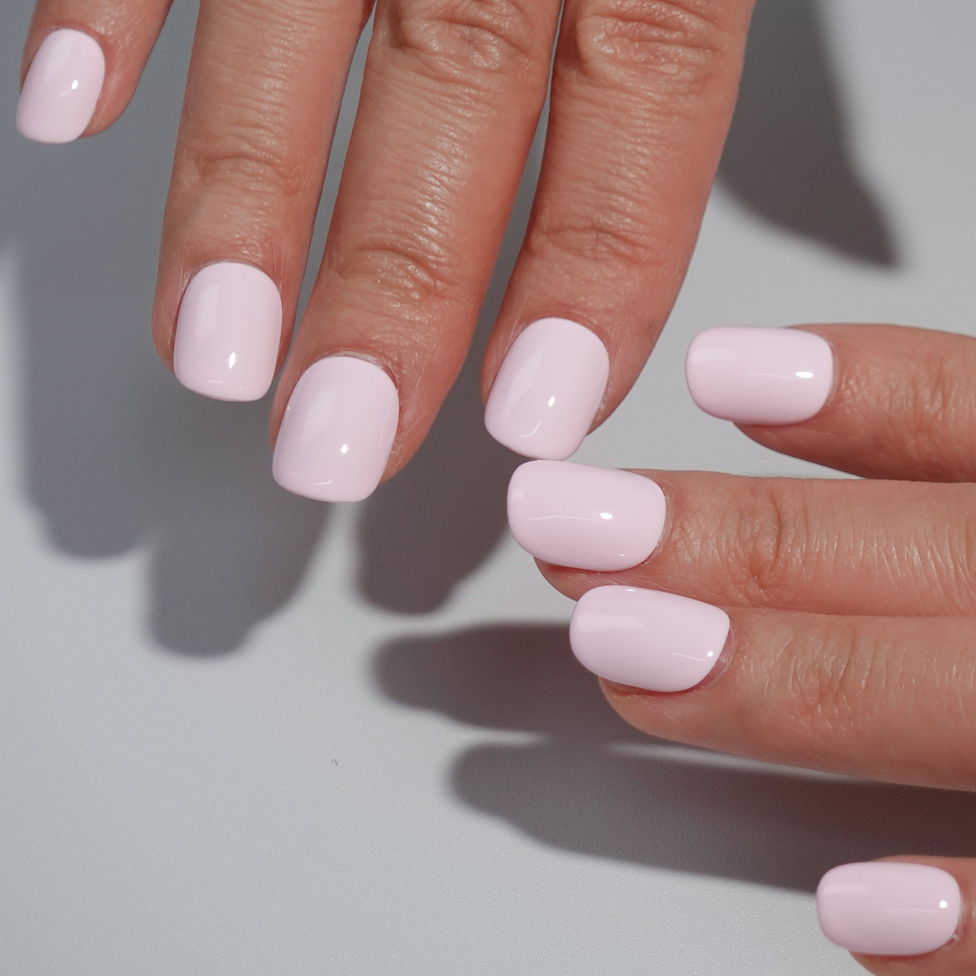 A set of light pink glossy press - on nails neatly arranged in a transparent case, featuring a gentle, smooth finish, ideal for romantic or feminine occasions.