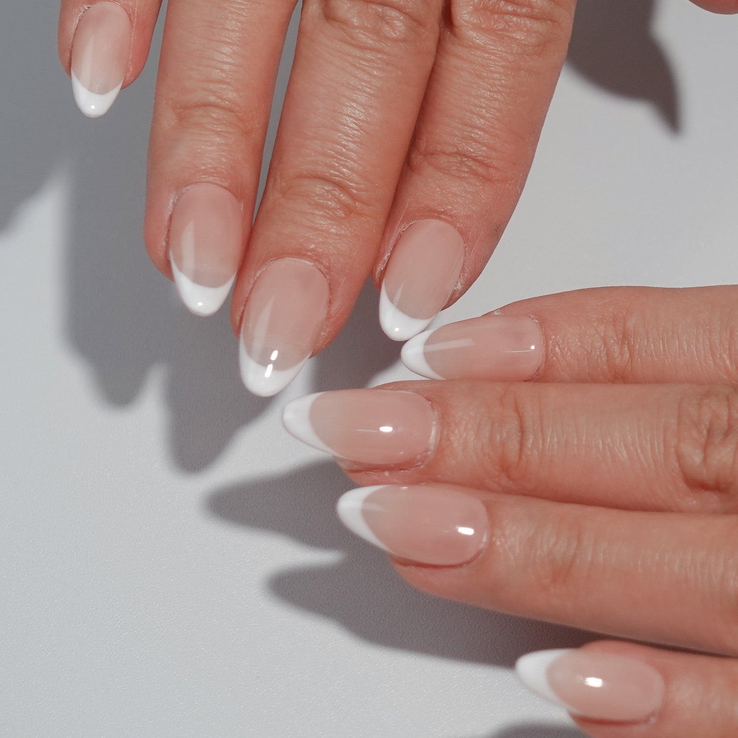 Ombre Glow nail set features a subtle ombre effect transitioning from deep smoky tones to light white tips, perfect for a sophisticated style.