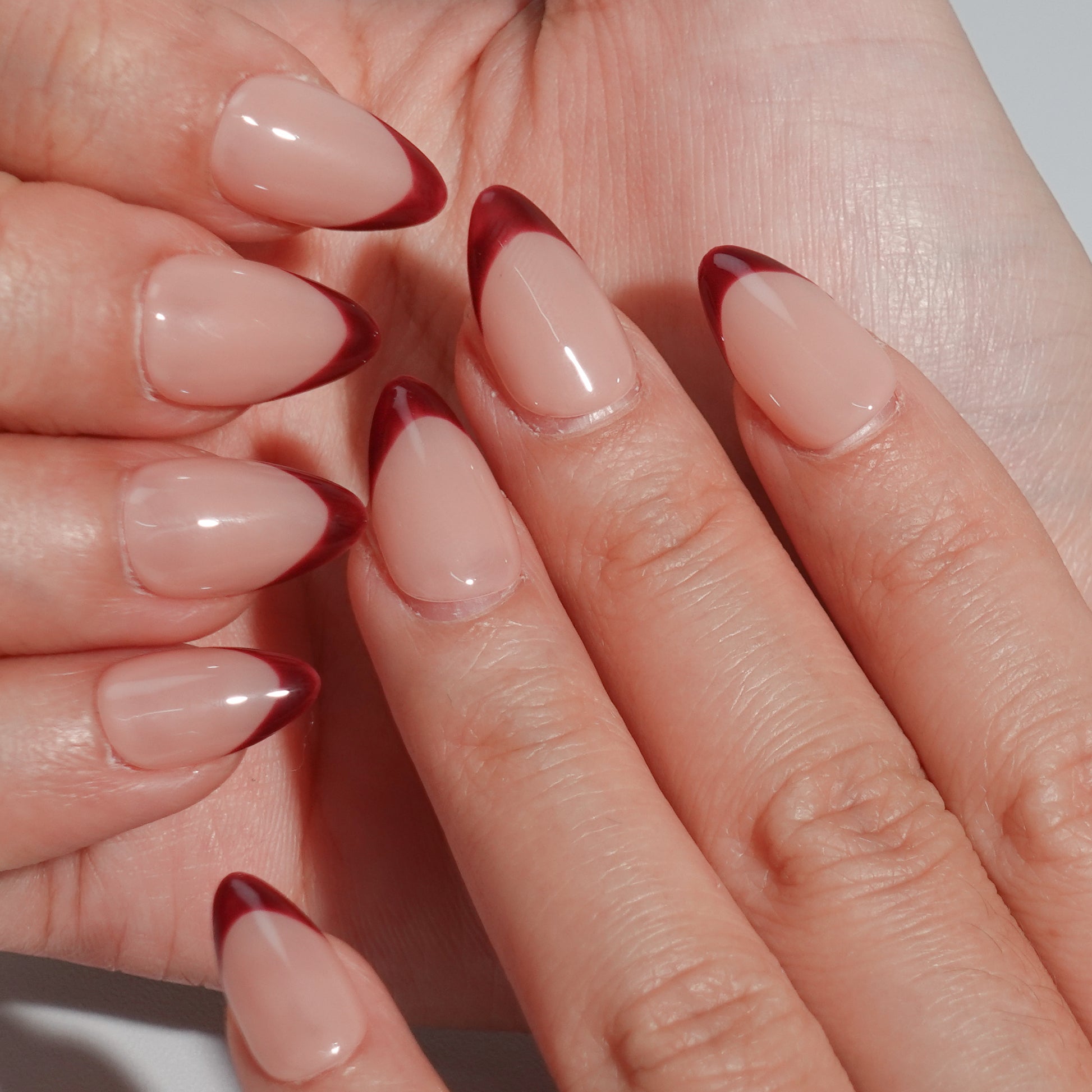 Deep brown French nails with almond-shaped design and smooth nude base, exuding noble elegance.